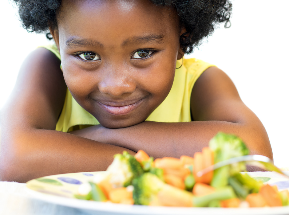 cute young african american girl with a plate of vegetables