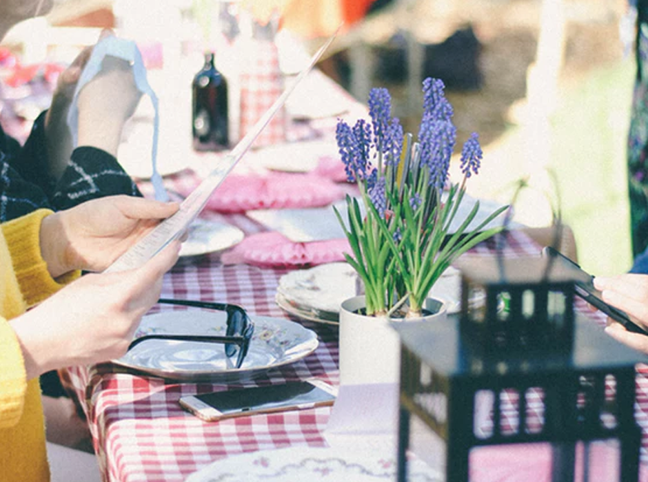 table set for lunch with a close up of a plant and woman's hand